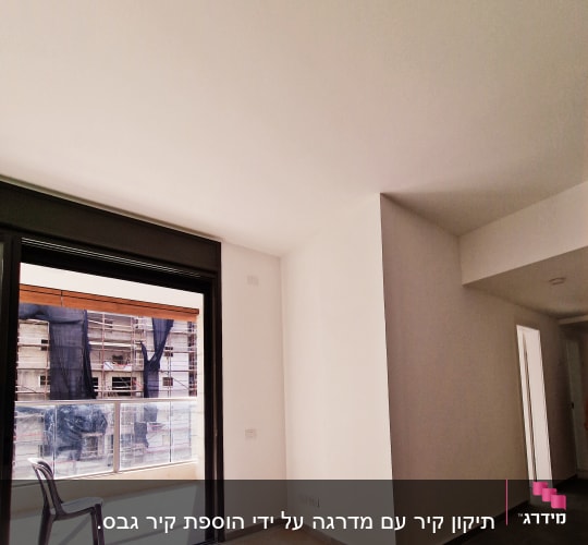 קירות גבס לבנים בחדר עם חלון גדול